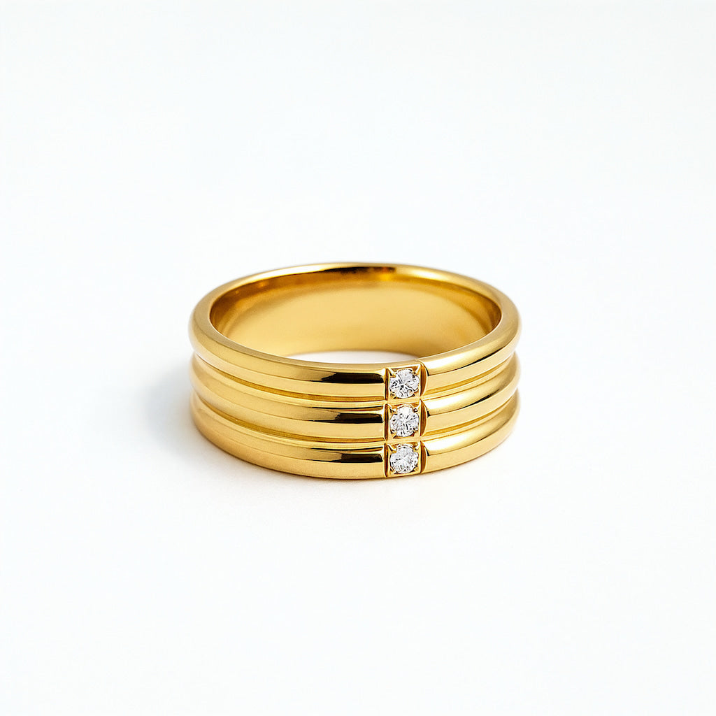 Gold ring with three stacked bands and three diamonds on a white background