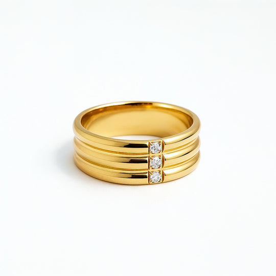 Gold ring with three stacked bands and three diamonds on a white background
